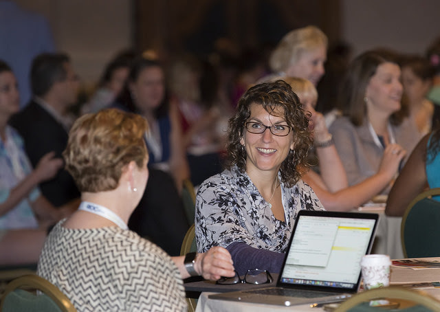 Cathy Bogaart at IABC conference chatting with attendees